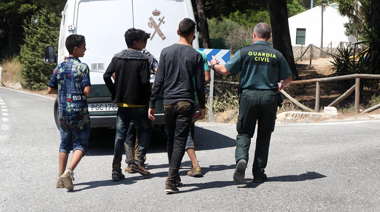 Un guardia civil acompaña a un grupo de menores extranjeros que se había escapado en Barbate