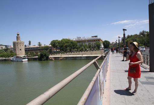 Una chica contempla el Guadalquivir desde el Puente de San Telmo