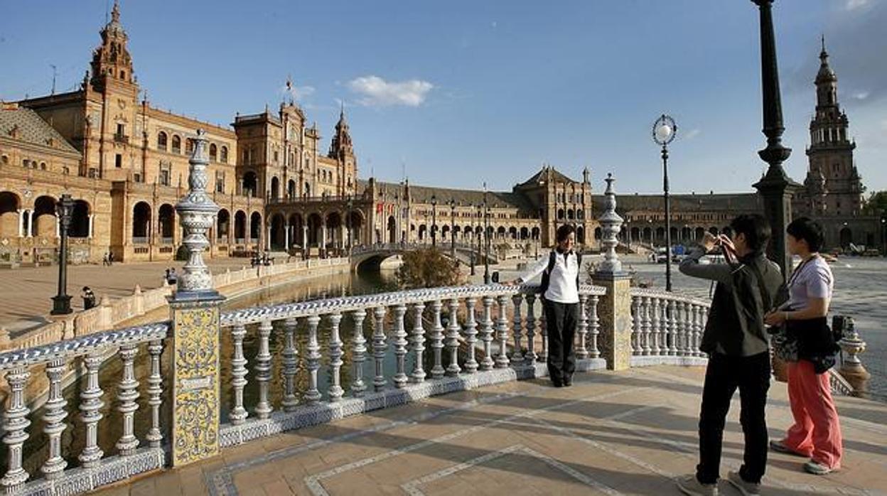 Unos turistas se fotografían desde uno de los puentes de la Plaza de España
