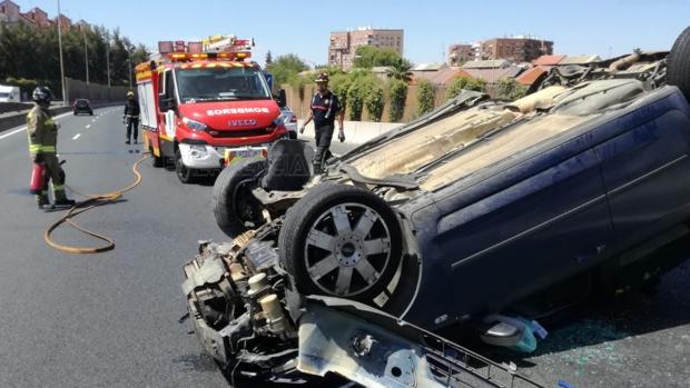 Una fuerte colisión en la SE-30 deja un vehículo volcado con el conductor atrapado en su interior