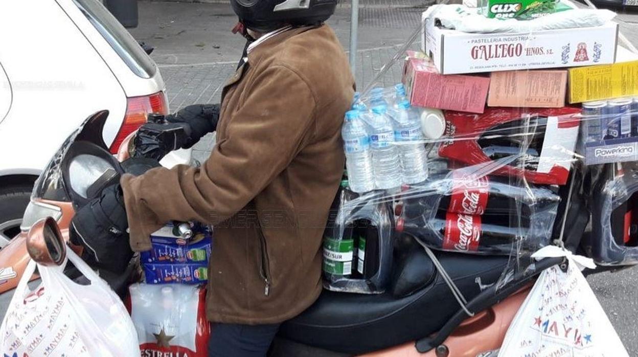 Un hombre transporta la compra en un ciclomotor