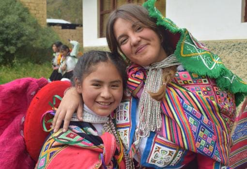 Mamen Jiménez, vestida con las coloristas ropas andinas, junto a una chiquilla en Perú
