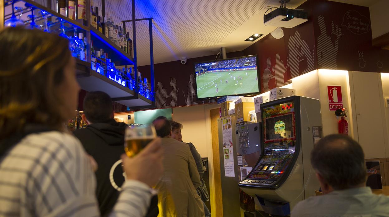 Clientes de un bar ven un partido de fútbol en la televisión