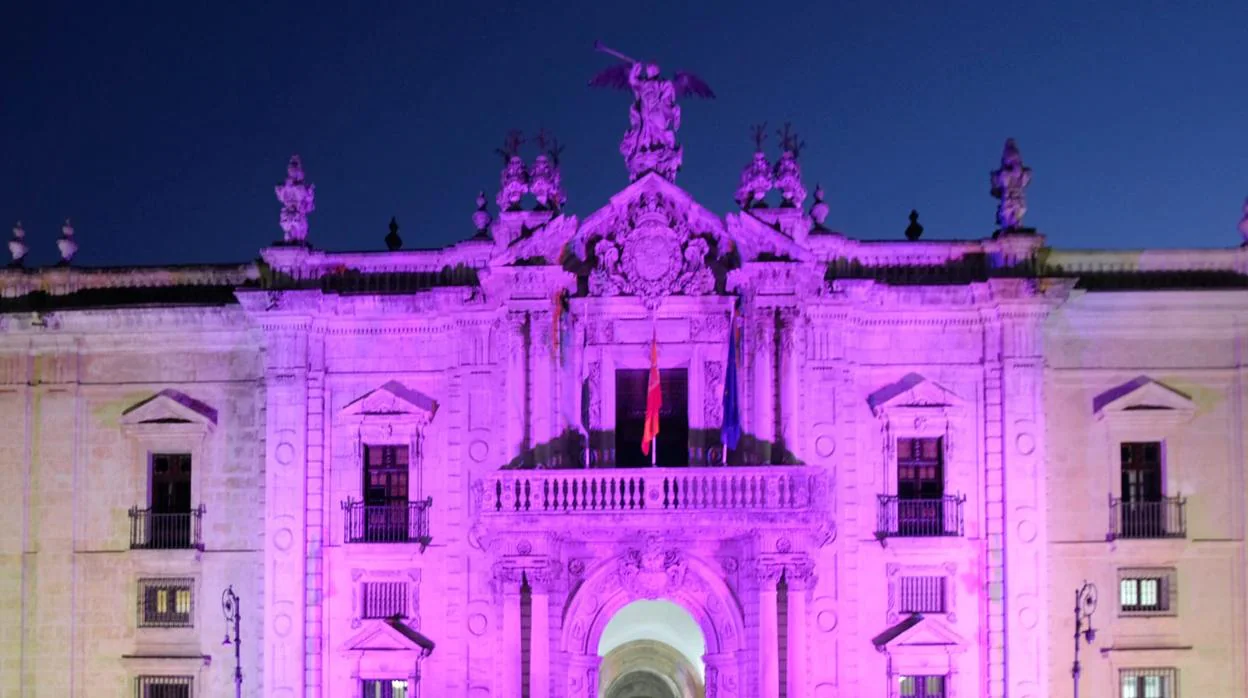 La fachada de la Universidad de Sevilla iluminada de rosa