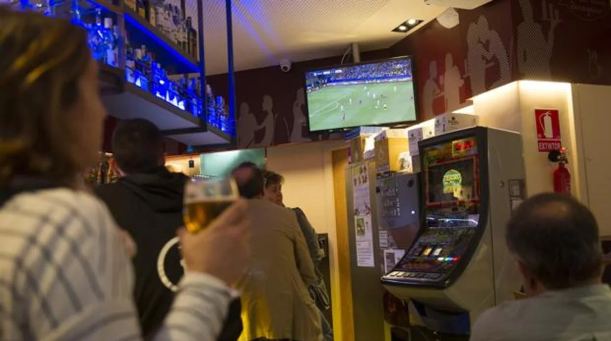 Clientes de un bar ven un partido de fútbol en la televisión