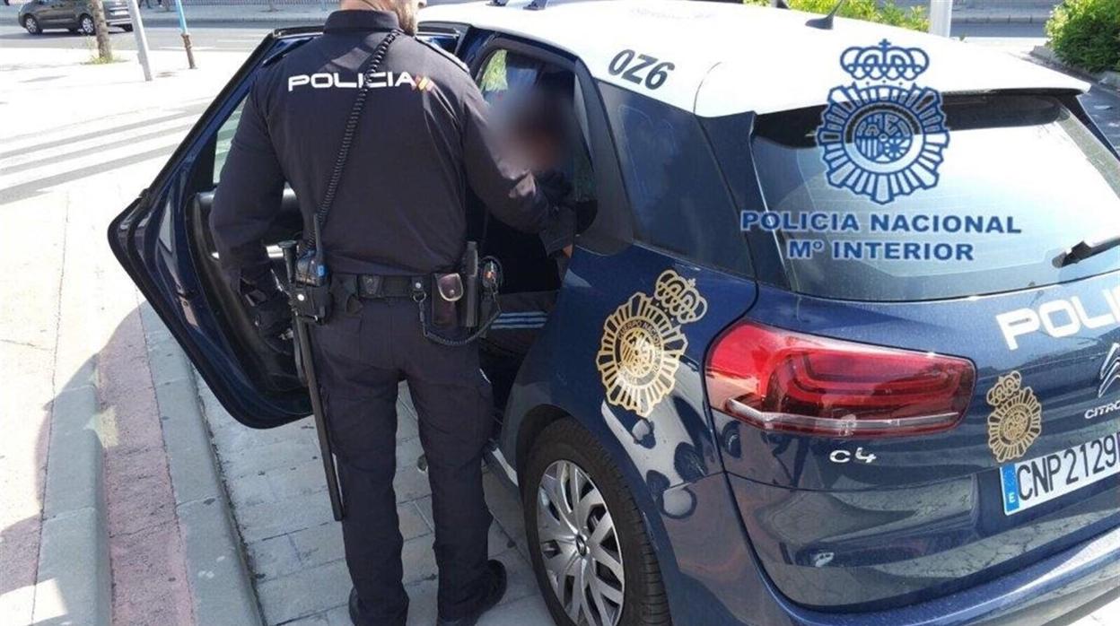 Imagen de archivo de un policía introduciendo en el coche patrulla a un detenido