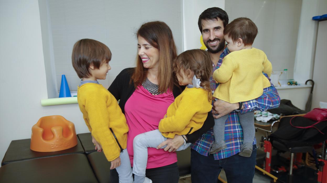 Mateo mira a su madre, Cristina, que también tiene en brazos a Carla (3). Ricardo, el padre, sostiene a Nacho (1)