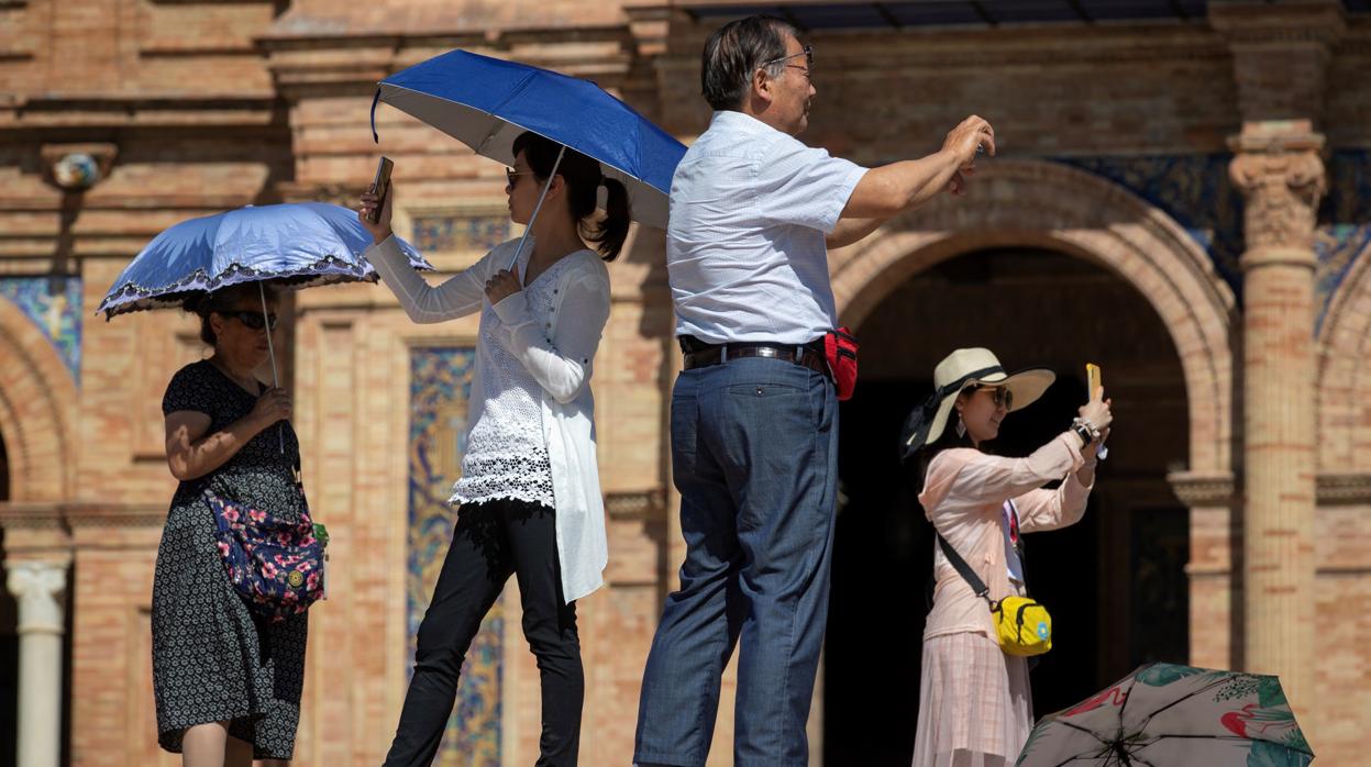 Turistas asiáticos visitando la Plaza de España de Sevilla