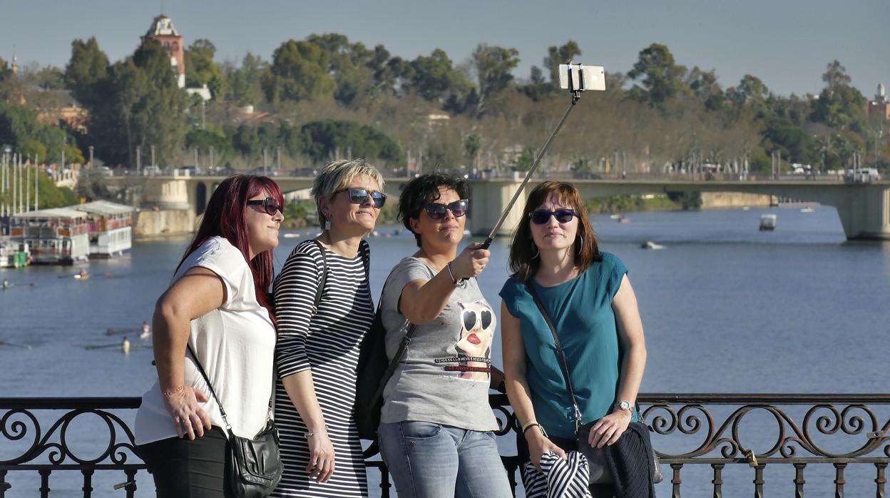 Un grupo de mujeres se hace un selfie en el puente de Triana de Sevilla