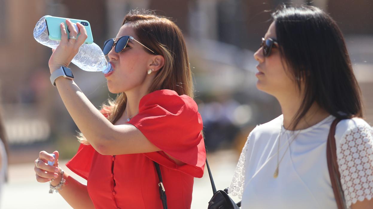 Una joven se hidrata bebiendo agua en Sevilla