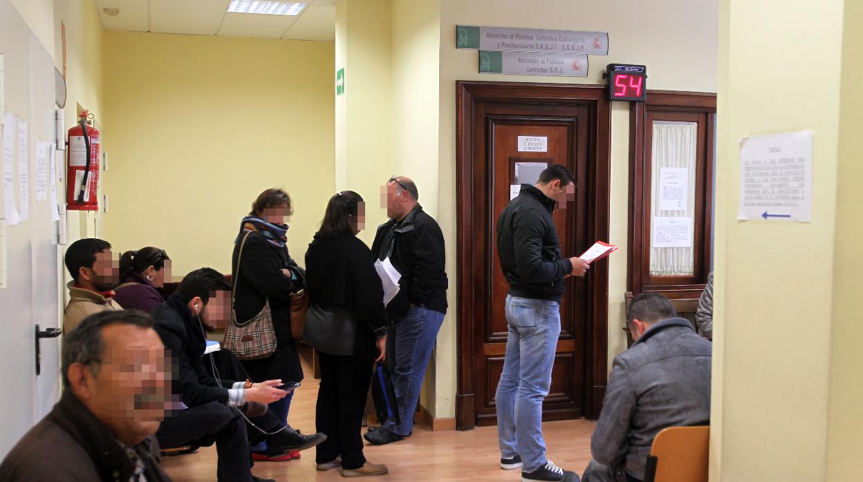 Ciudadanos esperando su turno para solicitar abogado de oficio en la Audiencia de Sevilla