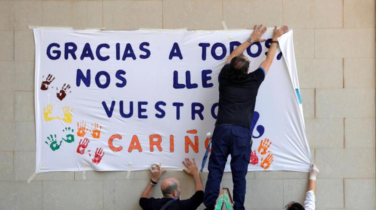 Trabajadores de un asilo colocando una pancarta de agradecimiento