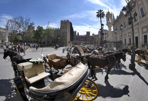 Coches de caballo en la plaza del Triunfo, con el Alcázar al fondo