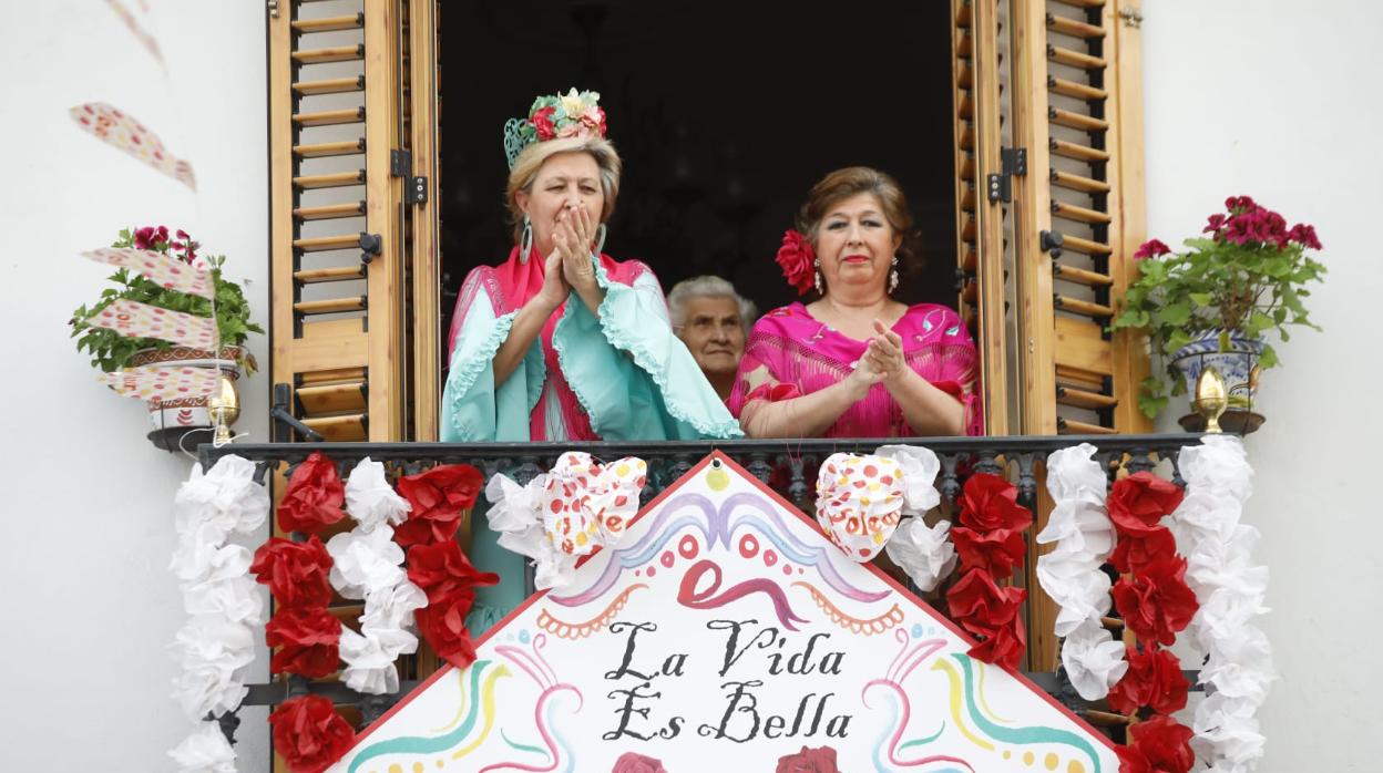 Mujeres vestidas de flamenca en un balcón de la calle Castilla