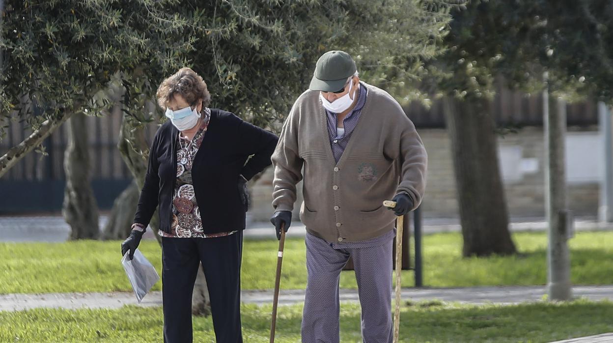 Dos ancianos pasean con mascarillas