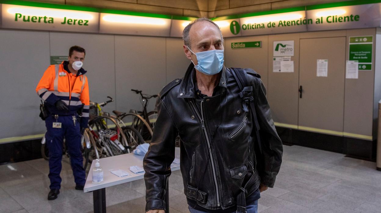 Un pasajero del metro tras recoger la mascarilla