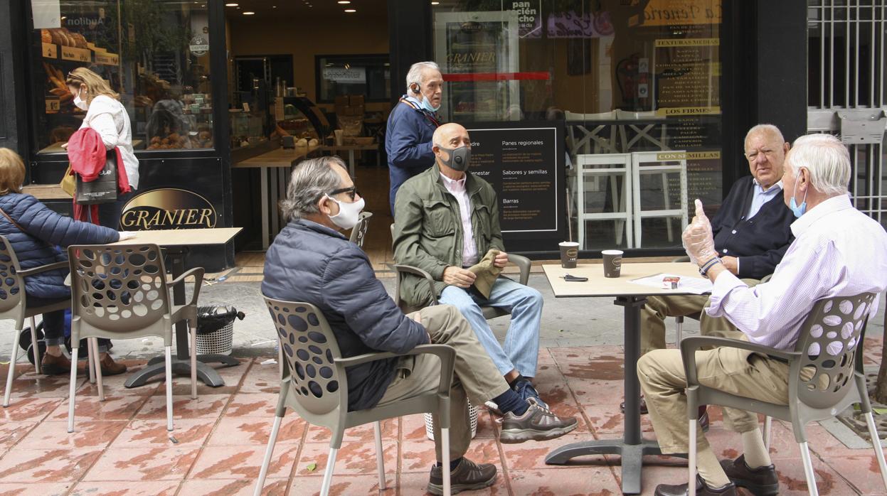 Varios clientes en una terraza en el primer día de apertura