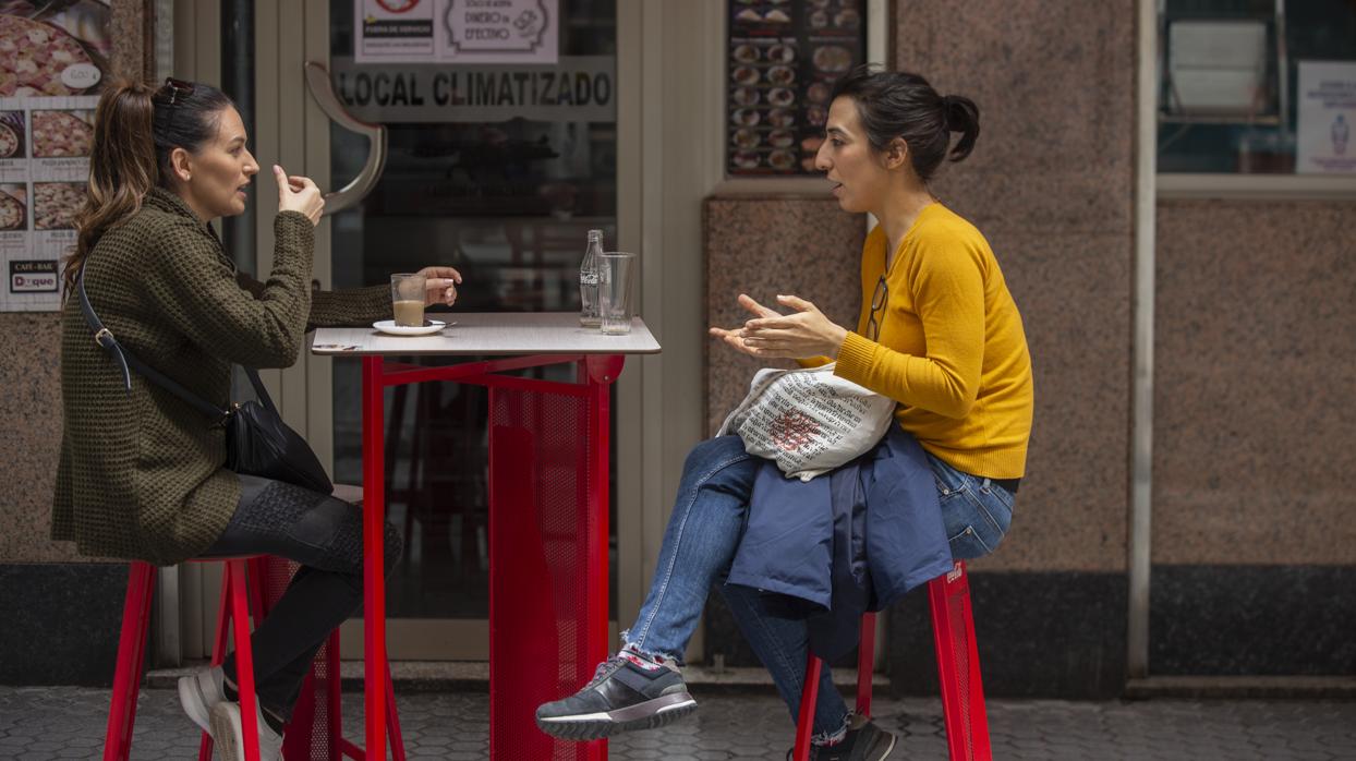 Dos personas desayunan en el velador de un bar