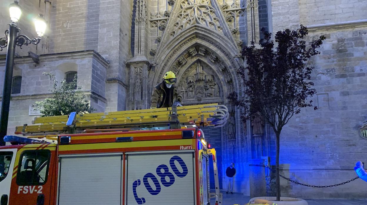 Dos bomberos de Sevilla ante la Puerta de San Miguel de la Catedral tras solucionar la emergencia