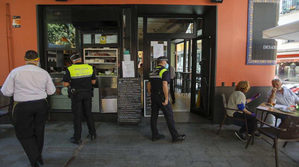 Agentes de la Policía Local de Sevilla, en plena labor de inspección de la terraza de un bar