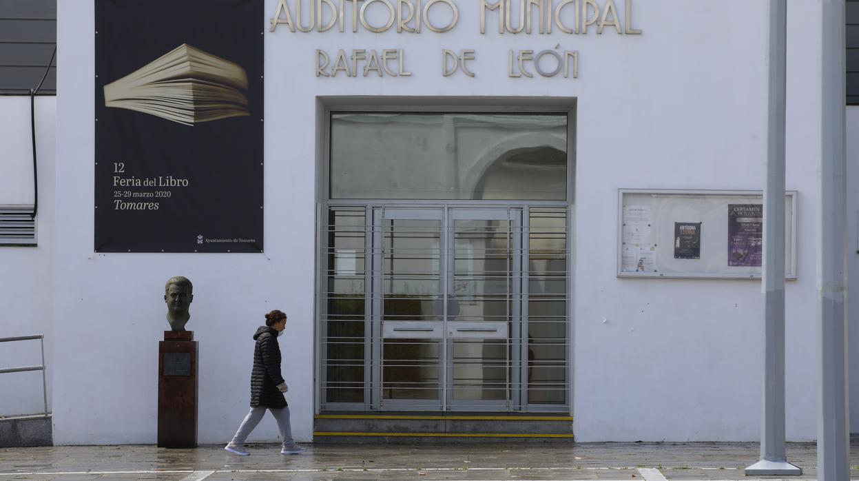 Una mujer camina ante el auditorio municipal de Tomares