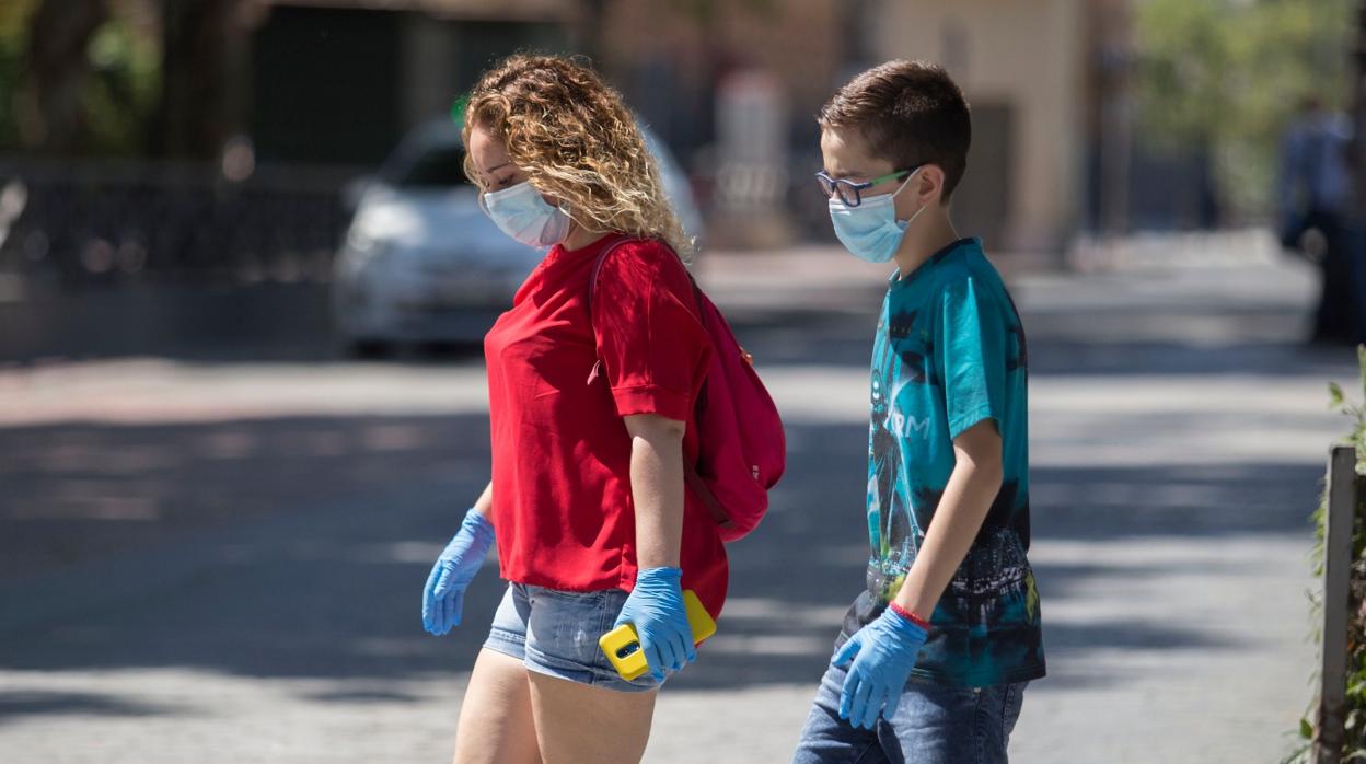 Dos adolescentes pasean por una calle de Sevilla