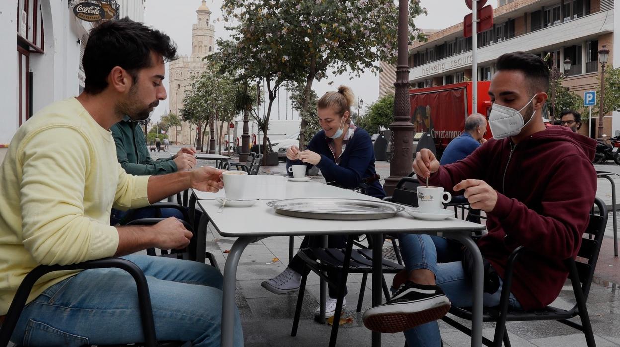 Dos jóvenes tomando un café en la calle Almirante Lobo de Sevilla