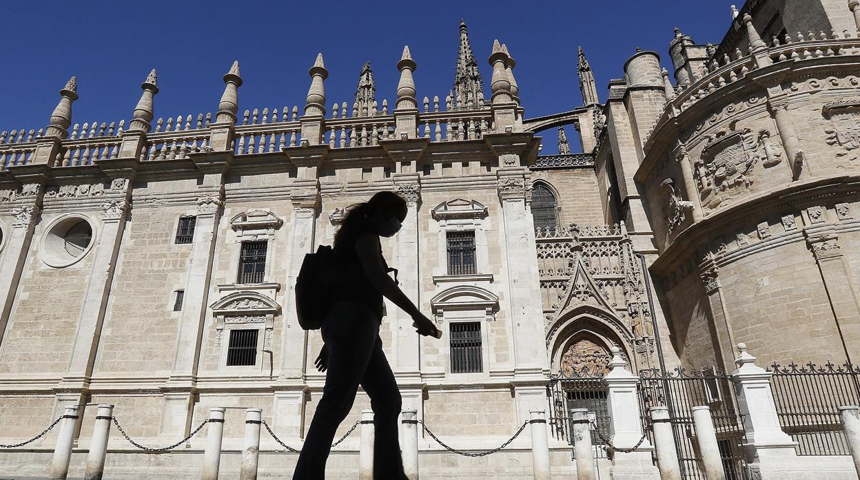 Una mujer camina por la sombra en los alrededores de la Catedral de Sevilla