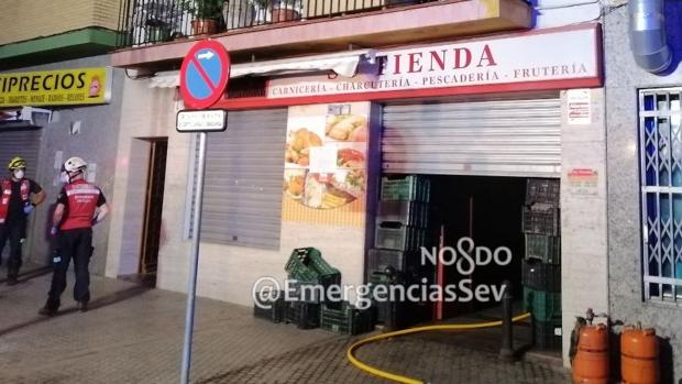 Los bomberos de Sevilla extinguen un incendio en una carnicería de Torreblanca