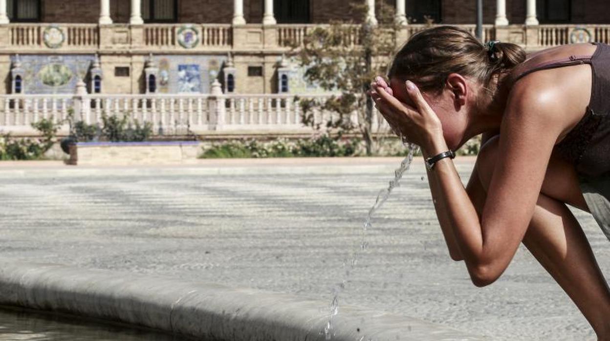 Una joven refrescándose en la fuente de la Plaza de España