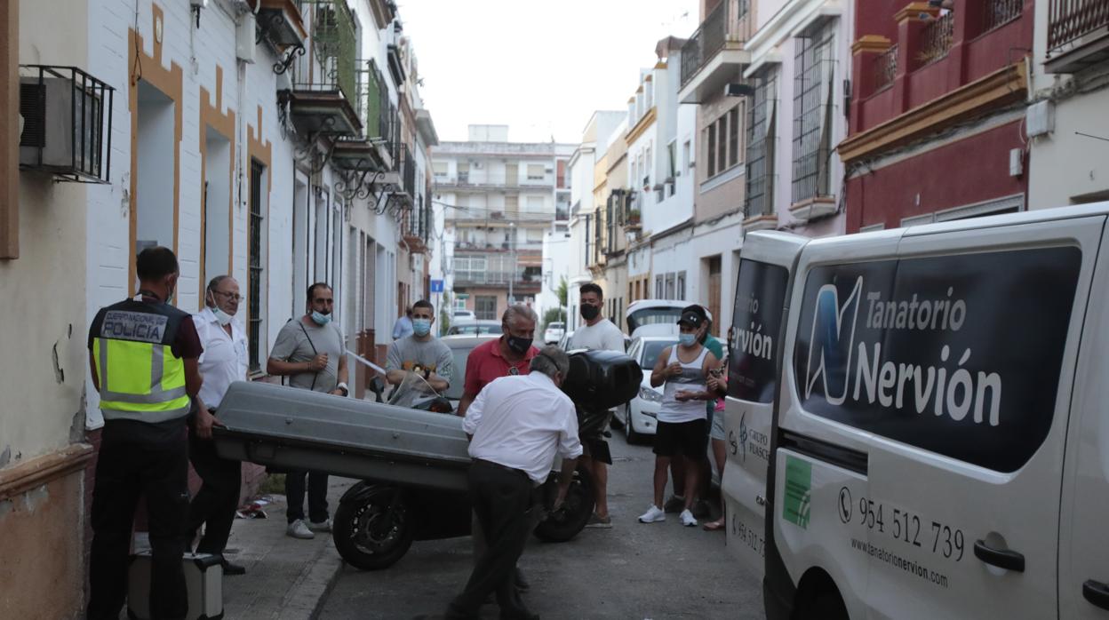 Los operarios de la funeraria sacan el cadáver del piso incendiado