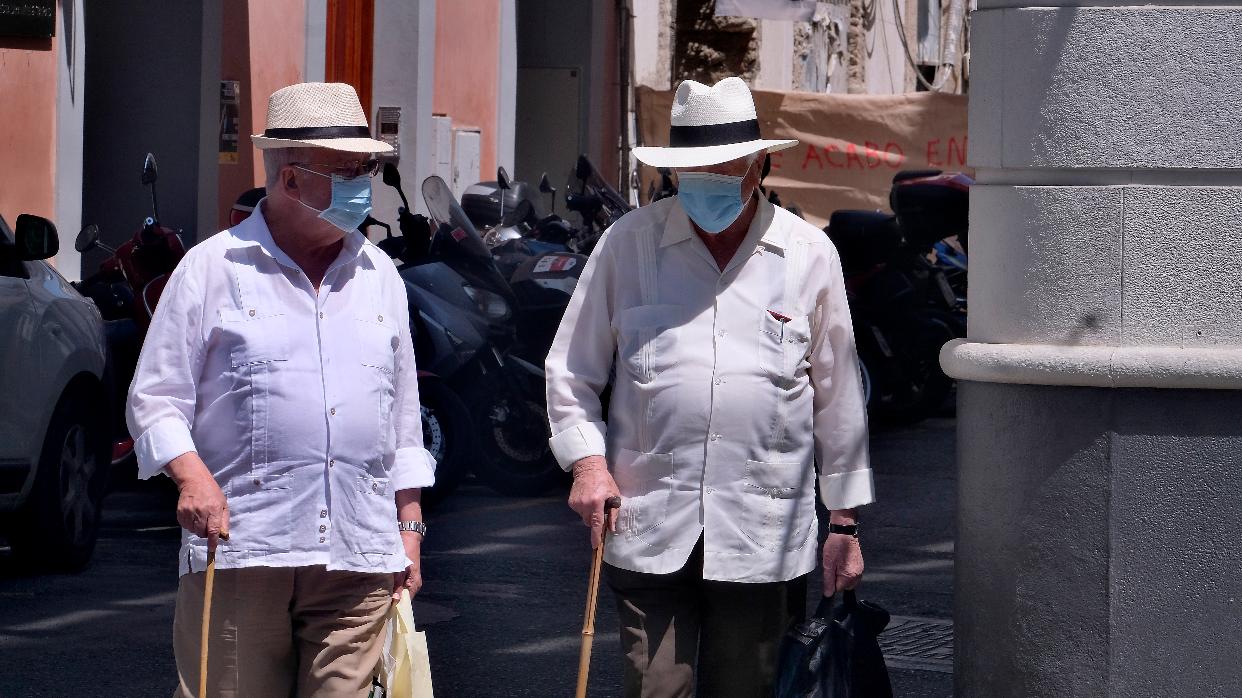 Dos transeúntes con mascarilla por las calles del Centro de Sevilla