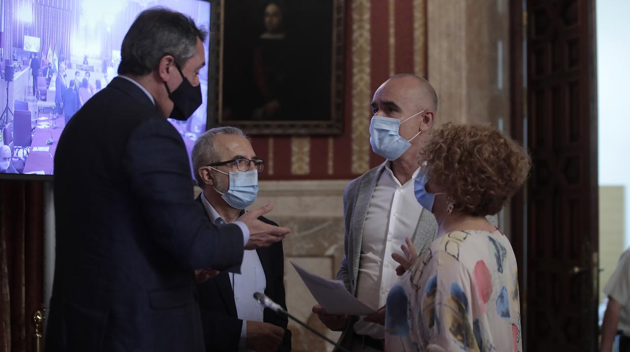 El alcalde, Juan Espadas, dialoga con varios miembros de su partido en el Pleno