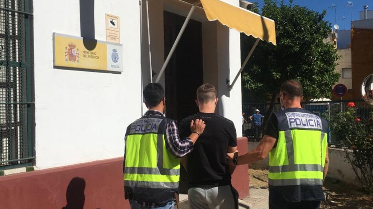 Los agentes trasladan a dependencias policiales a un joven detenido en Sevilla, en una imagen de archivo