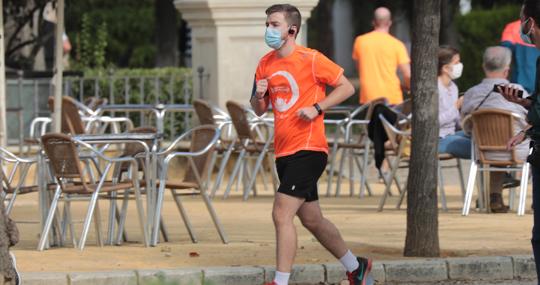 Un corredor haciendo deporte con mascarilla en Sevilla