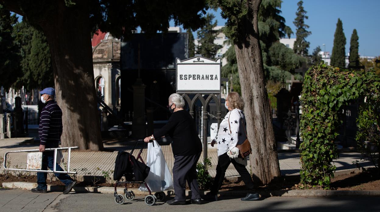 Tres sevillanos discurren por la calle Esperanza del cemtenerio