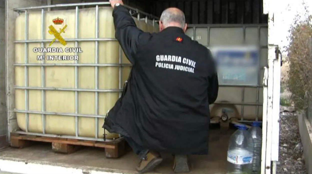 Un agente de la Guardia Civil inspecciona contenedores de plástico con gasoil robado en una operación del año 2014