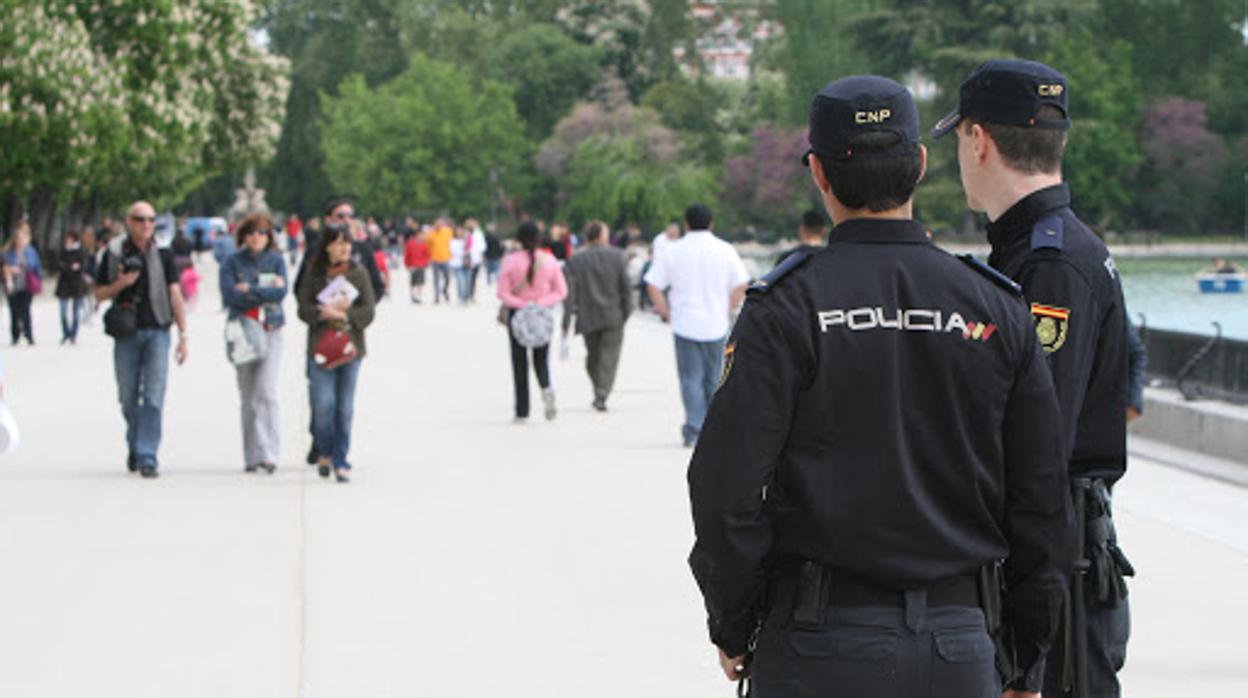 Dos policías patrullan por un parque