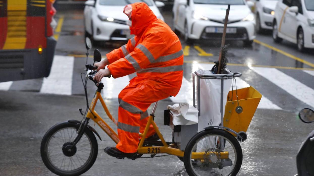 Varias personas hacen cola en Sevilla protegidos de la lluvia por sus paraguas