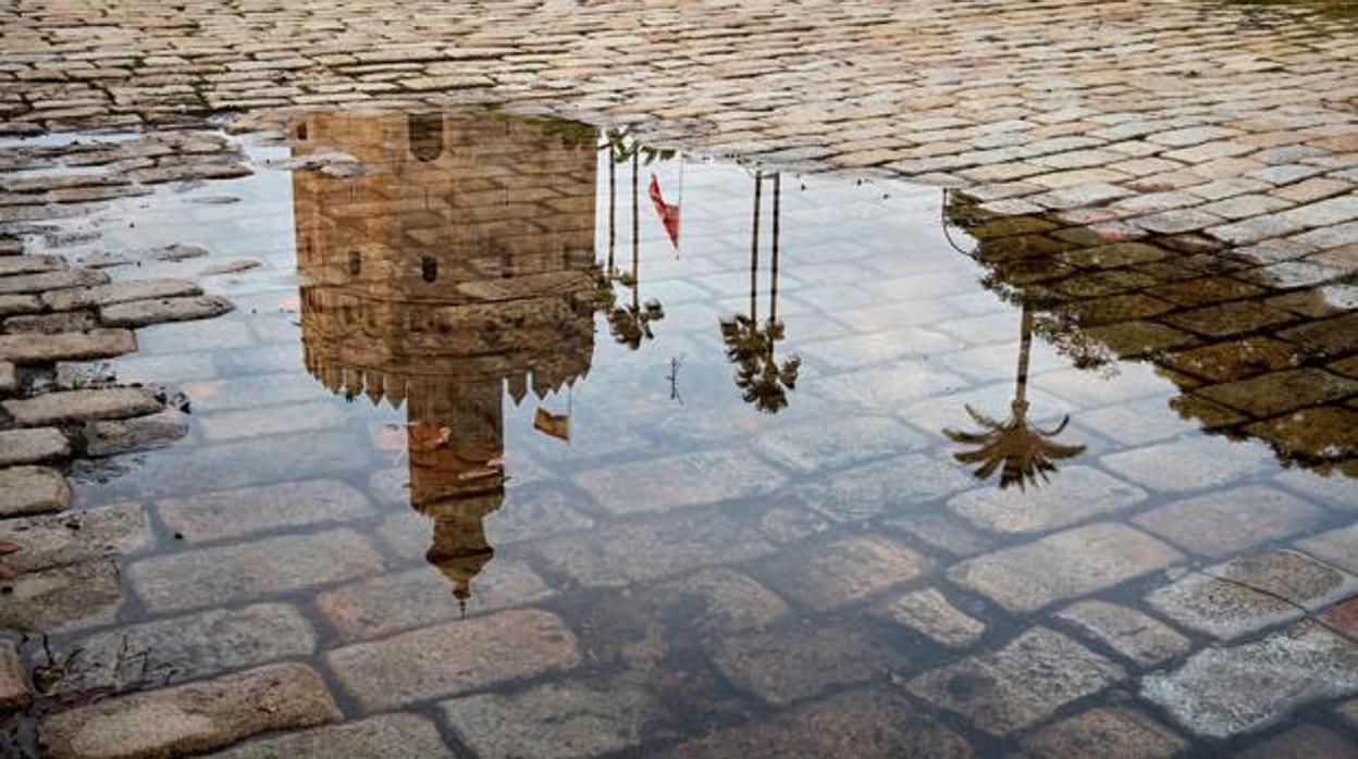 La Torre del Oro, reflejada en un charco formado por las lluvias