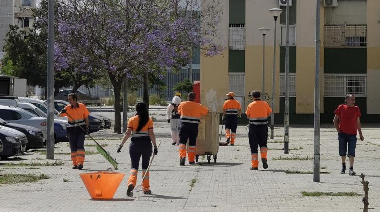 Operarios de Lipasam limpiando una calle del Polígono Sur