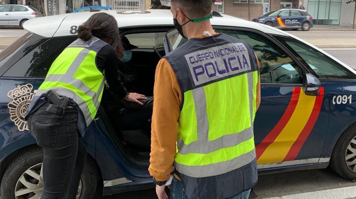 Los agentes sacan a uno de los detenidos del coche para conducirlo a dependencias policiales