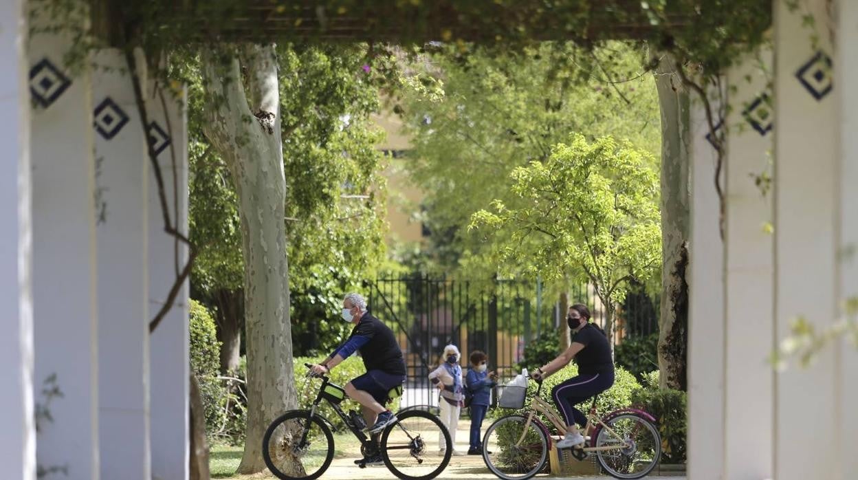 Dos personas pasean en bici por el parque