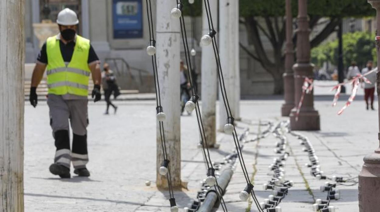 Operarios instalando las luces y los postes de la 'Feria' del Centro