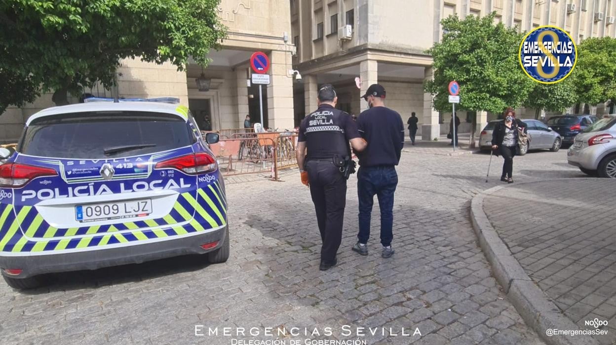 Un agente de la Policía Local traslada al edificio judicial al detenido por el atropello de la Ronda del Tamarguillo