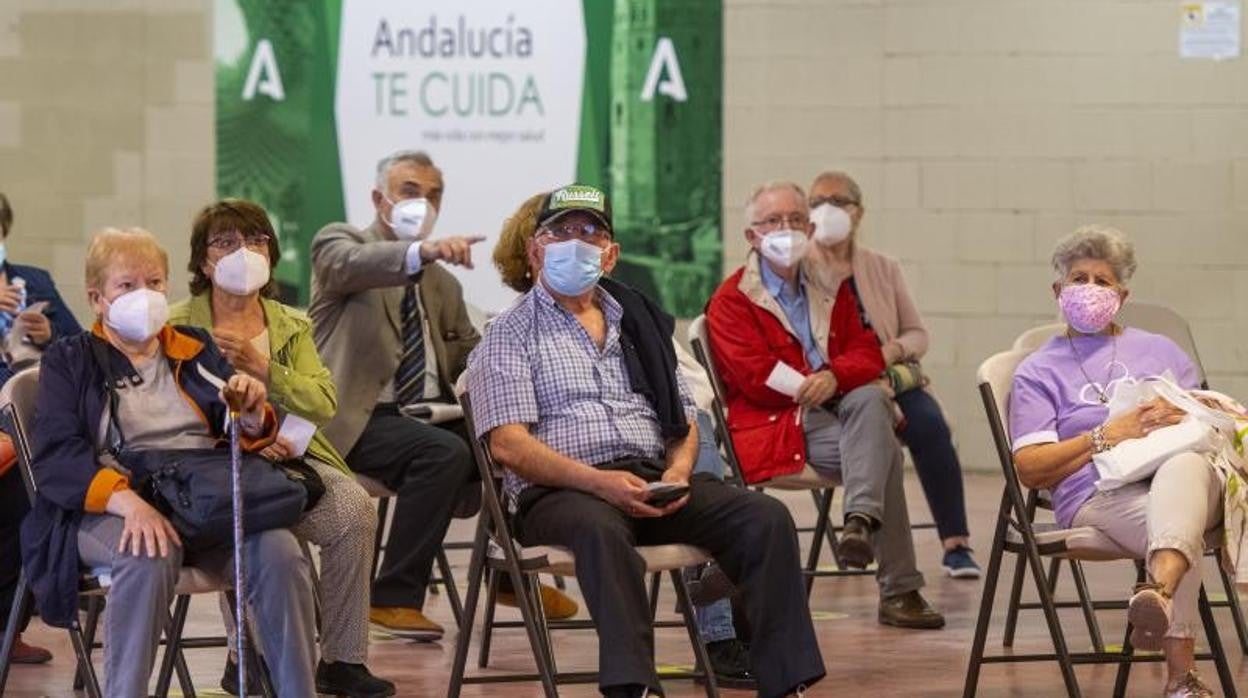 Varias personas aguardan su turno para vacunarse en el estadio de la Cartuja