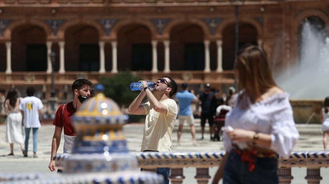 Una persona se refresca en la Plaza de España