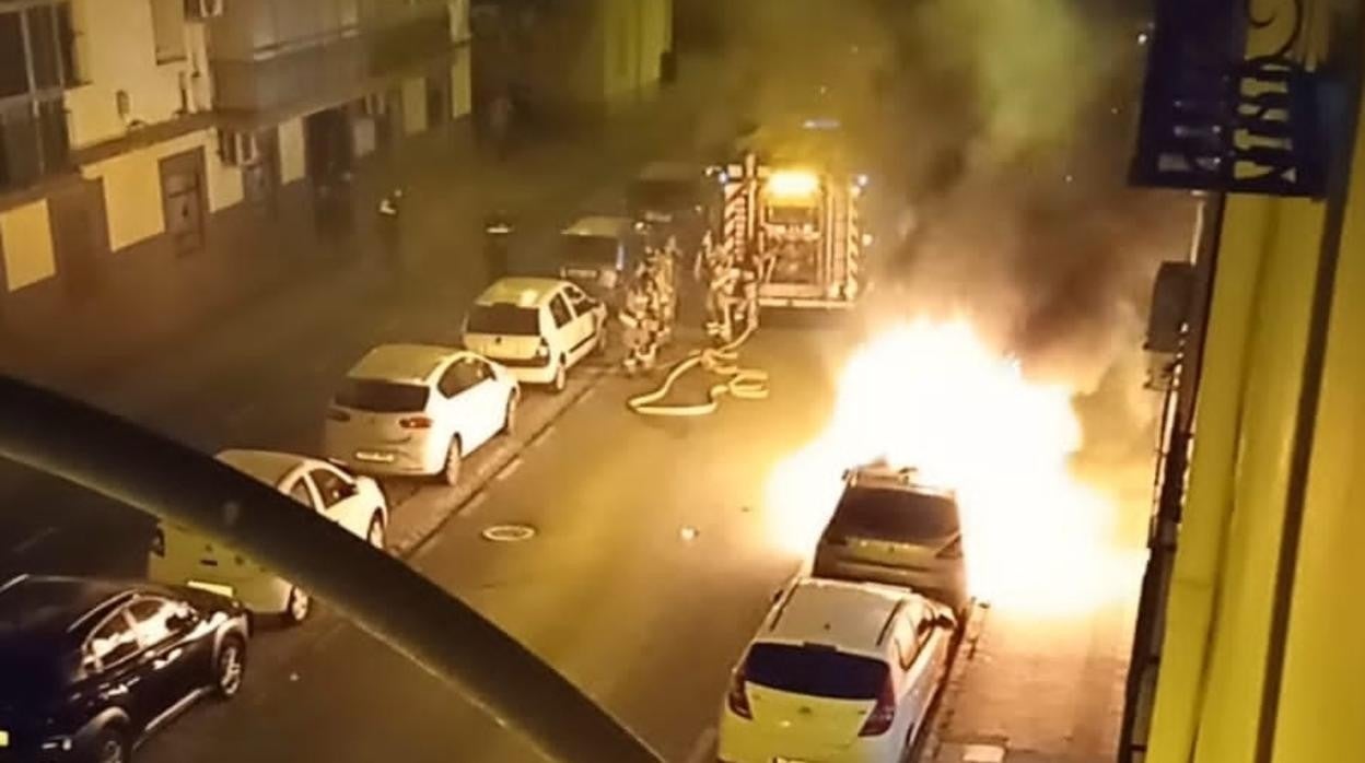 Momento de actuación de los Bomberos apagando los vehículos afectados en la calle Madreselva