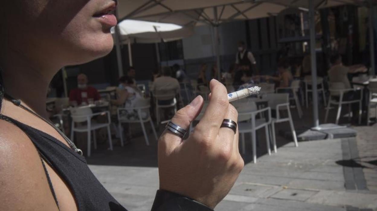 Una mujer fuma en la calle