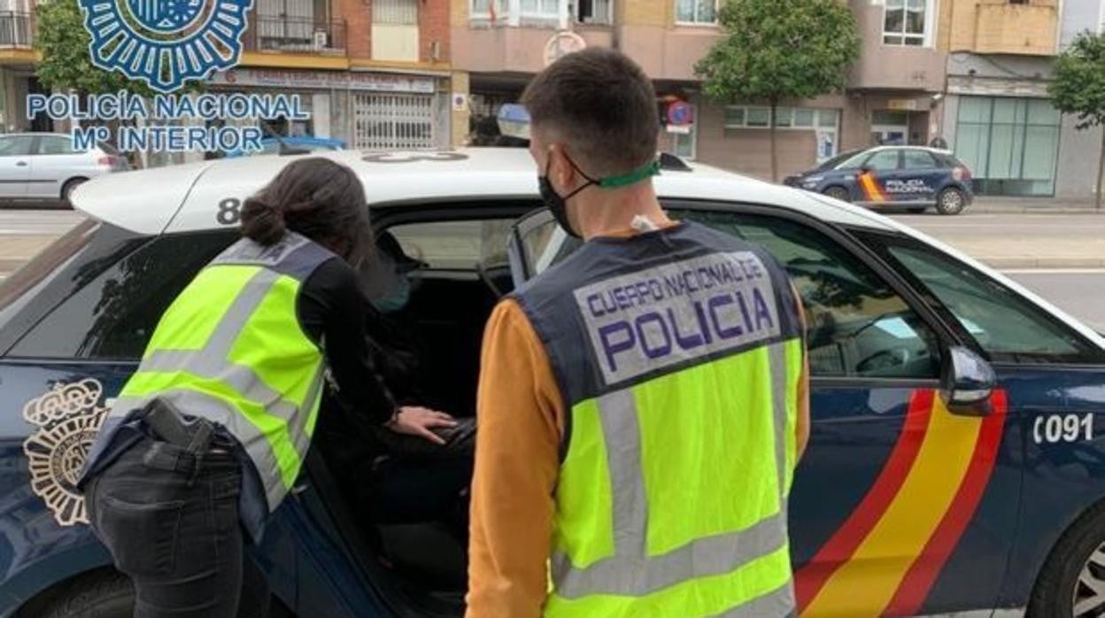 Dos policías sacan a un detenido por cometer robos violentos en una imagen de archivo